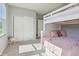 Cozy bedroom showcases a bunk bed, closet with sliding doors, and plush pink pillows and throws at 9656 Summerton Dr, Fishers, IN 46037