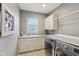 Well-lit laundry room features sink, cabinets, counter, and washer/dryer for added convenience at 9656 Summerton Dr, Fishers, IN 46037