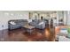 Open-concept living space showcasing a large sectional, hardwood floors, and a glimpse of the kitchen at 9656 Summerton Dr, Fishers, IN 46037