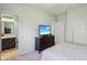 Well-lit bedroom features a dresser, white bedding, and a doorway into the bathroom at 9656 Summerton Dr, Fishers, IN 46037
