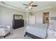 Inviting main bedroom has tray ceiling, dresser, chair, white trim, and ensuite bathroom at 9656 Summerton Dr, Fishers, IN 46037