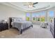 Spacious main bedroom with tray ceiling, windows, neutral walls, and soft carpeting at 9656 Summerton Dr, Fishers, IN 46037