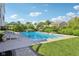 Backyard swimming pool surrounded by lush greenery, perfect for summertime relaxation and recreation at 9656 Summerton Dr, Fishers, IN 46037