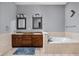 Bright bathroom with double vanity, granite countertops, and soaking tub with tile surround at 970 Fort Wayne Ave # 303, Indianapolis, IN 46202