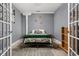 Cozy bedroom with a stylish bed, neutral walls, and a view from french doors to another room at 970 Fort Wayne Ave # 303, Indianapolis, IN 46202