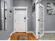 Well-lit hallway featuring hardwood floors, decorative mirror, and doors leading to other rooms at 970 Fort Wayne Ave # 303, Indianapolis, IN 46202