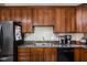 A kitchen with wood cabinets, granite countertops, stainless steel sink, and black appliances at 970 Fort Wayne Ave # 303, Indianapolis, IN 46202