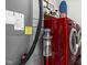 A modern laundry room with a red washer and dryer set, storage shelf, and a vacuum at 970 Fort Wayne Ave # 303, Indianapolis, IN 46202