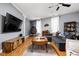 A living room with hardwood floors, gray sectional sofa, and a large TV at 970 Fort Wayne Ave # 303, Indianapolis, IN 46202