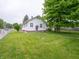 Charming house with white siding, green trim, and a well-maintained lawn and mature trees at 1065 36Th St, Indianapolis, IN 46208