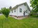 A charming two-story home with white siding, green trim, and a well-manicured lawn at 1065 36Th St, Indianapolis, IN 46208
