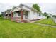Charming single-story home with green lawn, white siding, and welcoming front porch with brick accents at 1065 36Th St, Indianapolis, IN 46208