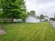 View of the one-car detached garage in a backyard with a well-maintained lawn and mature trees at 1065 36Th St, Indianapolis, IN 46208