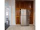 Galley kitchen featuring stainless refrigerator, ample wood cabinets, and tile flooring at 1065 36Th St, Indianapolis, IN 46208