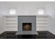 Bright living room with built-in shelving surrounding a fireplace, enhanced by beautiful dark hardwood floors at 1065 36Th St, Indianapolis, IN 46208