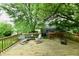 Inviting wooden back deck surrounded by mature trees, perfect for outdoor relaxation at 1106 W 4Th St, Anderson, IN 46016
