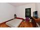 Bedroom with hardwood floors, small window, and TV on dresser at 1106 W 4Th St, Anderson, IN 46016