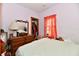 Cozy bedroom featuring a wooden dresser, closet, and window with a red curtain at 1106 W 4Th St, Anderson, IN 46016