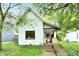 Charming home featuring an inviting front porch, complemented by mature trees, and an access ramp at 1106 W 4Th St, Anderson, IN 46016
