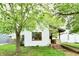 Charming home featuring an inviting front porch, complemented by mature trees, and an access ramp at 1106 W 4Th St, Anderson, IN 46016
