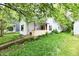 Charming home featuring an inviting front porch, complemented by mature trees, and an access ramp at 1106 W 4Th St, Anderson, IN 46016