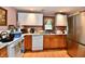 Well-equipped kitchen featuring stainless steel refrigerator and wood cabinets at 1106 W 4Th St, Anderson, IN 46016