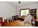Room with hardwood floors, window, chair, and playpen in need of decluttering at 1106 W 4Th St, Anderson, IN 46016