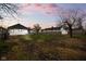 A spacious backyard with a wooden fence and small storage shed under a sunset sky at 1216 N Ewing St, Indianapolis, IN 46201