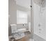 Bathroom with a white shower/tub combination, toilet, window, and white walls at 1216 N Ewing St, Indianapolis, IN 46201