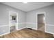 Dining room with wood flooring, gray walls, white trim, and views into the kitchen and a bedroom at 1216 N Ewing St, Indianapolis, IN 46201