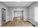 Open concept living room features wood flooring, gray walls, white trim and natural light from the window at 1216 N Ewing St, Indianapolis, IN 46201