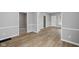 Open concept living room features wood flooring, gray walls, white trim, and multiple entryways at 1216 N Ewing St, Indianapolis, IN 46201
