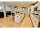 An open-concept kitchen features a large island, white cabinetry, stainless steel appliances, and hardwood floors at 14020 Brookstone Dr, Carmel, IN 46032