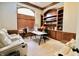 An executive office boasts custom built-ins, a large desk, and cozy recliner seating at 14020 Brookstone Dr, Carmel, IN 46032