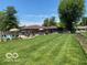 Spacious backyard featuring a pool, patio with seating, partial privacy fence, and a lush green lawn at 1425 Winding Trail Cir, Greenwood, IN 46142