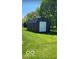 New storage shed with a roll-up door in a spacious backyard at 1425 Winding Trail Cir, Greenwood, IN 46142
