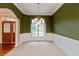 Classic dining room with wainscoting, a chandelier, and a large window with backyard views at 1589 Belleflower Ct, Avon, IN 46123