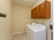Well-lit laundry room featuring a washer, dryer, and plenty of storage cabinets at 1589 Belleflower Ct, Avon, IN 46123