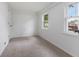 A sunlit bedroom features neutral carpeting, crisp white walls, and two windows providing ample natural light at 1606 Asbury St, Indianapolis, IN 46203