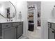 Bathroom with gray vanity, round mirror, and open view into closet at 17359 Wilkes Way, Westfield, IN 46074