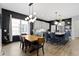 Modern kitchen featuring sleek cabinetry, a large island with seating, and an adjacent dining area with stylish lighting at 17359 Wilkes Way, Westfield, IN 46074