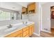 Bathroom featuring double sinks, wooden cabinets, a large mirror, and access to storage at 18278 Benton Oak Dr, Noblesville, IN 46062