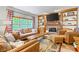 Comfortable living room with fireplace, built-in shelving, and a large window at 18278 Benton Oak Dr, Noblesville, IN 46062