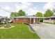 Brick house exterior with a covered back porch, fire pit and manicured landscaping at 2110 Allison Ave, Speedway, IN 46224