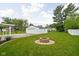 Spacious backyard featuring a fire pit, detached garage, and well-maintained lawn at 2110 Allison Ave, Speedway, IN 46224