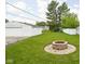 Landscaped backyard with a stone fire pit, green lawn, and a detached two-car garage at 2110 Allison Ave, Speedway, IN 46224