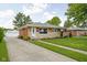 Charming single-story home with brick and stone facade, lovely landscaping, and a long concrete driveway at 2110 Allison Ave, Speedway, IN 46224