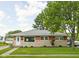 Charming single story house with nicely maintained lawn and stone with brick accenting the facade at 2110 Allison Ave, Speedway, IN 46224