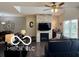 Cozy living room featuring a fireplace, modern ceiling fan and lots of natural light at 217 N Liberty Blvd, Mooresville, IN 46158