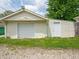 A detached one-car garage with an accompanying side door is on a gravel driveway with a patch of grass at 2528 S Pennsylvania St, Indianapolis, IN 46225